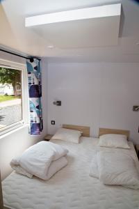 迪尔巴克Tornade的一间卧室设有两张床和窗户。