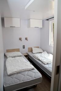 迪尔巴克Tornade的白色墙壁客房的两张床