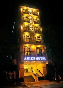 绥和市Aries Hotel的一家在晚上读酒店标志的酒店