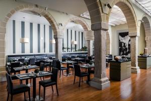 赫雷斯-德拉弗龙特拉Eurostars Asta Regia Jerez的一间在房间内配有桌椅的餐厅