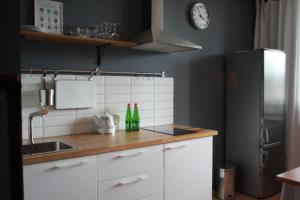 圣彼得堡邦邦切公寓的厨房配有白色橱柜、水槽和冰箱。
