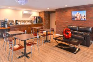 普特南Motel 6 Putnam CT的餐厅设有桌椅和皮沙发