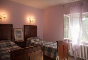 MonterubbianoCasa vacanze a Rubbianello的一间卧室设有两张床和窗户。