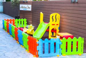 新马尔马拉斯Meliton Inn Hotel & Suites by the beach的色彩缤纷的木玩具围栏,设有游乐场
