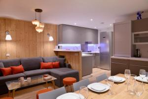 贝勒普拉涅Belle Plagne Premium的客厅以及带沙发和桌子的厨房。
