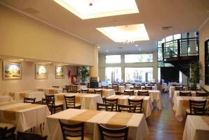 戈亚戈雅康达赌场酒店的一间设有白色桌椅的用餐室