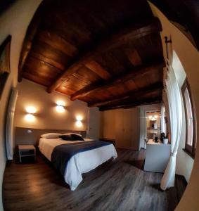 瓦拉洛Delzanno的一间卧室设有一张带木制天花板的大床