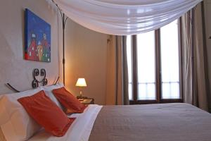布宜诺斯艾利斯A酒店的卧室配有白色的床、红色枕头和窗户