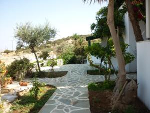 阿里克海滩Manolis Farm Guest House的一座种有树木和石头人行道的花园