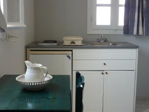 阿里克海滩Manolis Farm Guest House的厨房配有水槽和桌上碗