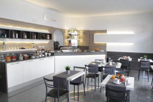 米兰赛洛酒店的厨房以及带桌椅的用餐室。