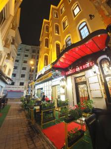 伊斯坦布尔锡尔凯奇加尔酒店的楼前有桌子和植物的街边咖啡馆