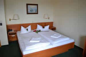 科尔平塞加尼瑟斯霍斯恩酒店的一张配有白色床单和鲜花的大床