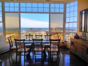 科拉雷侯Mision Costa的一间带桌椅和大窗户的用餐室