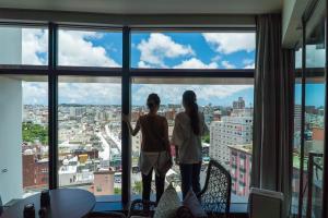 那霸那霸花开JR九州酒店的两个女孩站在窗前