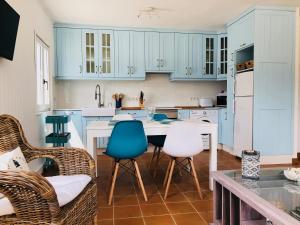 圣马尔塔奥尔蒂盖拉Esteiro Surf Lodge的厨房配有蓝色橱柜和桌椅