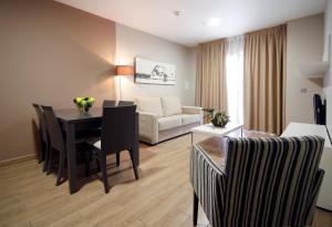 哈卡雅卡塔尼亚Spa及公寓酒店的客厅配有桌椅和沙发