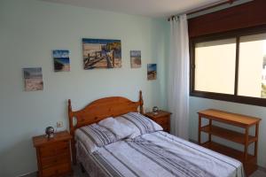 滨海罗克塔斯Retro Mint - Las Cigüeñas的一间卧室设有床、两张桌子和一扇窗户