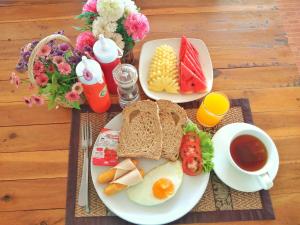 高兰兰达拉帕亚度假村的早餐盘包括鸡蛋和面包以及一杯咖啡