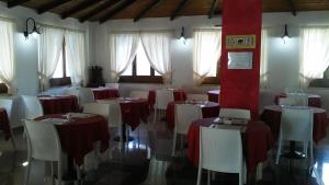 维耶斯泰Hotel Parco Carabella partner Elite Hotels的一间设有红色和白色桌椅的用餐室