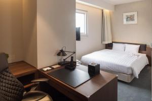 吴市克莱顿海湾酒店的配有一张床和一张书桌的酒店客房