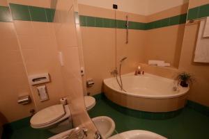 特尔尼郁金香经典酒店的带浴缸、卫生间和盥洗盆的浴室