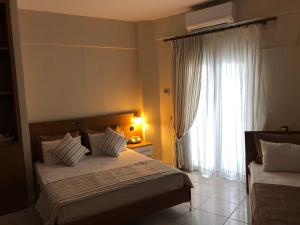 阿莫利亚尼岛阿莫利亚尼酒店的一间卧室设有两张床和大窗户