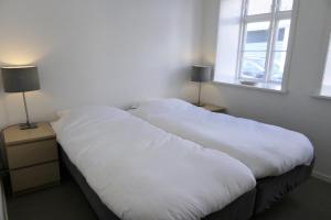 德拉厄德拉厄酒店及公寓的带窗户的客房内的2张白色床