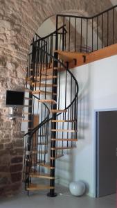 Saint-Jean-et-Saint-Paul德高塔姆红磨坊住宿加早餐旅馆的木楼梯,位于一个石墙房间内