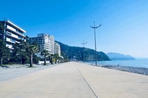 高尼奥Villa Georgiana的一条空的街道,在海边,有建筑