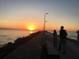 洛肯Villa Vendel B&B的站在码头上观看日落的男人和女人