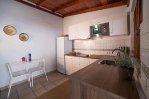 丰卡连特德拉帕尔马Villas Los Torres I的厨房配有水槽、桌子和微波炉
