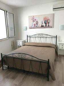 莱乌卡Estatesalento的一间卧室设有一张床和两个窗户。