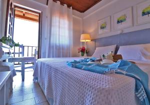 阿吉奥斯伊欧尼斯肯奇康精品酒店与简易别墅的卧室配有一张白色的床、桌子和窗户。