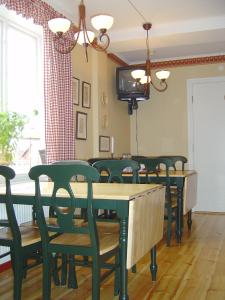 JättendalHotell Mellanfjärden的一间配备有绿色椅子和桌子及电视的用餐室