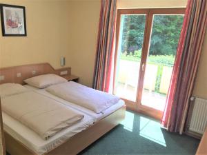 施里斯海姆施呃德酒店的一间卧室设有一张床和一个大窗户