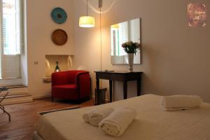孔韦尔萨诺D'Aragona 56的一间卧室配有一张床、一张红色椅子和一面镜子