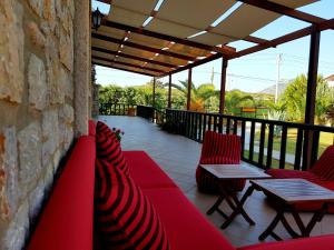 达特恰Villa Kizlan Ova的一个带红色桌椅的庭院和石墙