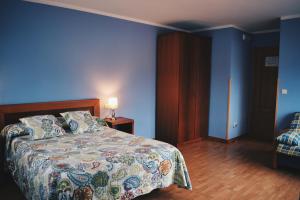 里瓦德塞利亚Hotel Brisas del Sella的一间卧室设有一张床和蓝色的墙壁