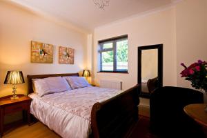 戈德尔明Godalming Hotel Guest House的一间卧室设有一张床和一个窗口