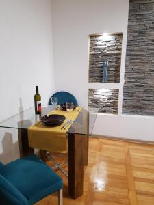 普洛耶什蒂Woodstone apartment的一间用餐室,配有玻璃桌和一瓶葡萄酒
