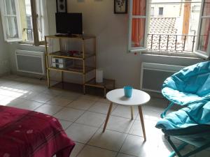 阿维尼翁Appartement Terrasse - Hypercentre的客厅配有桌子和电视