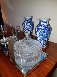 马亚My Home in OPorto的桌子上两只带眼镜的蓝白花瓶
