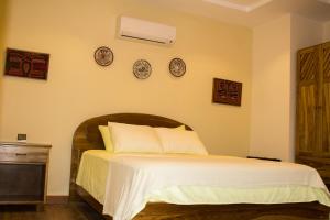 戴维Hotel-Boutique Patampa的一间卧室配有一张铺有白色床单的床,墙上挂有钟。