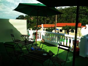 格罗韦Mar de Rosas的阳台的天井配有椅子和遮阳伞。
