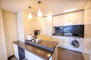 釜山普利布兰科酒店公寓的厨房配有白色橱柜、洗衣机和烘干机