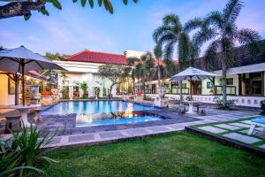 登巴萨巴厘岛英娜遗址酒店的一座房子的院子内的游泳池