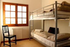 卡隆赫Villa Catalana的一间卧室配有两张双层床和椅子