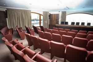 拉奎拉迪莫拉德尔巴索酒店的一个带红色椅子和讲台的讲座大厅
