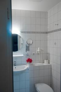 吕根岛上的维克Lieblingsplatz Bohlendorf Rügen的白色瓷砖浴室设有水槽和卫生间